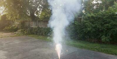 fogos de artifício coloridos acesos na calçada de asfalto com fumaça foto