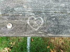 grafite em formato de coração esculpido em mesa de madeira foto