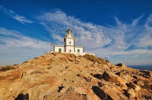 farol em uma rocha na ilha de santorini, grécia foto