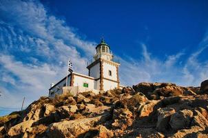 farol em uma rocha na ilha de santorini, grécia foto