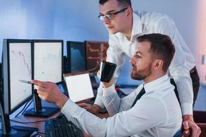 ocupação profissional. dois corretores de ações trabalhando no escritório com tecnologia de câmbio foto