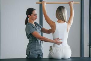 exercícios de coluna. mulher está no centro de saúde recebendo ajuda do médico foto