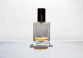 foto de um frasco de perfume de vidro transparente com uma pequena quantidade de perfume. foto de frente.