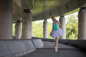 bailarina graciosa fazendo exercícios de dança em uma ponte de concreto foto