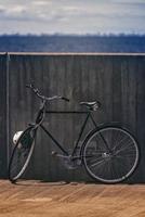 bicicleta preta vintage clássica, encostado na parede foto