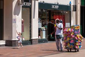 royal tunbridge wells, kent, reino unido, 2009. homem gerando muitas bolhas no shopping center em royal tunbridge wells foto