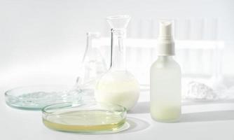 conceito de beleza fermentado. placas de petri, vidraria de laboratório e produtos cosméticos em uma mesa. ingrediente de cosmetologia enzimática. foto