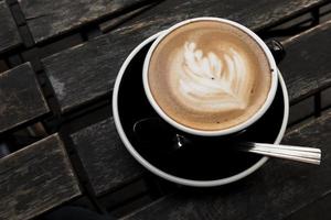 café com leite quente na mesa de madeira velha foto