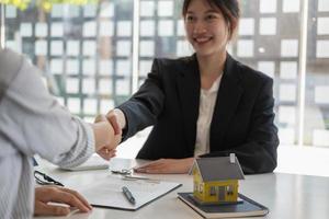 garantias, hipotecas, assinaturas, contrato, conceito de acordo, agentes imobiliários apertam as mãos dos clientes após a assinatura do contrato e os felicitam após chegarem a um acordo. foto