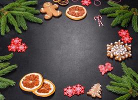 mesa festiva de natal com eletrodomésticos, pães de gengibre, galhos de árvores e árvores cítricas secas foto