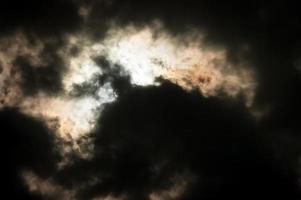 bela paisagem de nuvens dramática com o sol se escondendo atrás das nuvens. foto