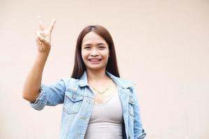 mulher asiática segurando dois dedos foto