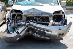 muitos carros quebrados após um acidente de trânsito no estacionamento de uma estação de serviço de restauração na rua. oficina de danos ao corpo do carro ao ar livre. venda de veículos de emergência seguros em leilão. foto