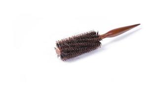 escova de cabelo redonda com cabelo perdido no fundo branco foto
