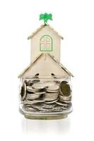 moedas em garrafa de vidro e casa em fundo branco, economia de negócios e conceito de investimento, incluem traçado de recorte foto
