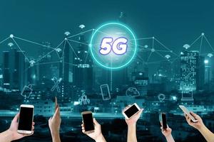 interface de rede 5g e conceito de ícone, mão segurando o telefone inteligente móvel com paisagem urbana foto