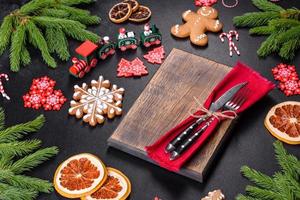 mesa festiva de natal com eletrodomésticos, pães de gengibre, galhos de árvores e árvores cítricas secas foto