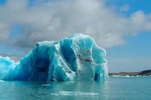 iceberg azul claro brilhante flutuando no lago jokulsarlon água fria azul na islândia 45 foto