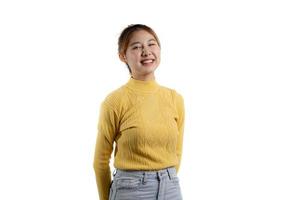 um retrato de uma linda mulher asiática em uma camisa amarela em pé sorrindo alegremente. conceito de retrato usado para propaganda e sinalização, isolado sobre o fundo em branco, copie o espaço. foto