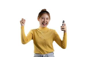 retrato de uma linda mulher asiática de camisa amarela jogando em um smartphone. conceito de retrato usado para propaganda e sinalização, isolado sobre o fundo em branco, copie o espaço. foto