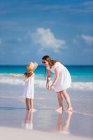 mãe e filha na praia, aproveitando seu tempo juntos foto