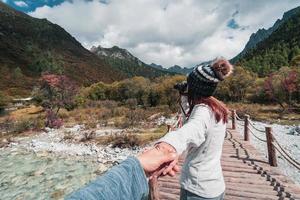 Caminhando jovem casal viajante olhando bela paisagem na reserva natural yading, conceito de estilo de vida de viagem foto