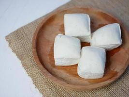 tofu de soja cru orgânico em recipiente de madeira. alimentos de ingredientes crus feitos de extrato de soja fermentado foto