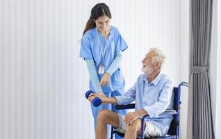 enfermeira do hospício está ajudando o homem caucasiano em cadeira de rodas a exercitar a força muscular no centro de aposentadoria de pensão para reabilitação de cuidados domiciliares e processo de recuperação pós-tratamento foto