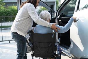 paciente asiático sênior ou idosa senhora sentada na cadeira de rodas preparar chegar ao carro dela, conceito médico forte saudável. foto