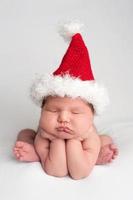 linda menina recém-nascida, usando um chapéu de Papai Noel