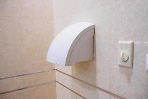 secador de mãos de banheiro automático no banheiro público foto