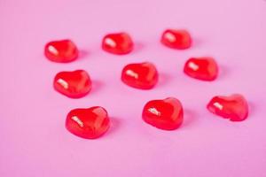 forma de corações de doces de dia dos namorados vermelho no fundo rosa foto