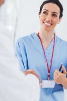 enfermeira feliz, agitando as mãos com médico foto