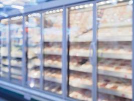 prateleiras de geladeira com carne no supermercado desfocar o fundo foto