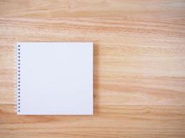caderno de capa branca no fundo da mesa de madeira marrom foto