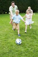 família jogando futebol no jardim foto