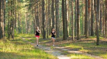 duas mulher correndo na floresta