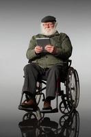 homem sênior na cadeira de rodas usando tablet digital foto