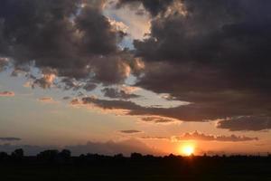 lindo pôr do sol da noite dourada com nuvens cor de rosa foto