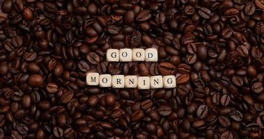 mensagem de bom dia no meio de muitos grãos de café torrados foto