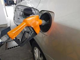 bomba de gasolina enchendo um carro foto