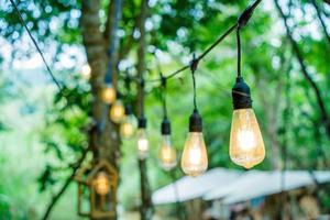 feche várias lâmpadas led em fundo verde bokeh. economizando energia, conceito ecológico. ftat lay, copie o espaço. as lâmpadas encontram-se em uma fileira. foto