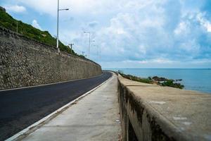 destino de viagem perfeito durante o pôr do sol em uma ilha no vietnã. hai longo litoral panorâmico com ondas, litoral, céu claro e estrada, mar azul e montanha. foto