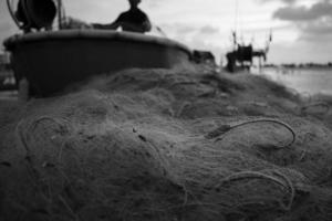 redes do mar - equipamento de pesca ou equipamento como pano de fundo de textura com luz solar natural e sombra. plano de fundo texturizado preto e branco de close-up de redes de pesca, design marinho para embarcações de pescadores. foto