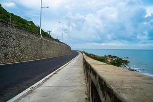 destino de viagem perfeito durante o pôr do sol em uma ilha no vietnã. hai longo litoral panorâmico com ondas, litoral, céu claro e estrada, mar azul e montanha. foto