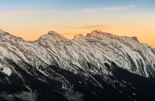 deslumbrante pôr do sol das montanhas rochosas canadenses cobertas de neve no parque nacional de banff em alberta, canadá foto