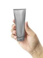 mão segurando o tubo de plástico cosmético isolado no fundo branco foto