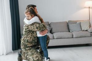 finalmente se encontram. soldado de uniforme está em casa com sua filha foto