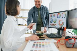 comunicação positiva. dois designers trabalhando juntos no escritório foto