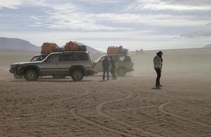 uyuni, bolívia - 10 de junho de 2016 - viajantes e jipes presos em uma tempestade de areia em uyuni, bolívia. foto